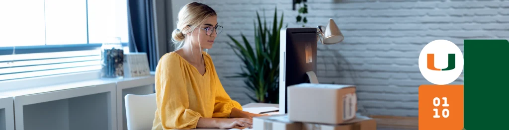 Woman in yellow top working on computer in a modern office setting