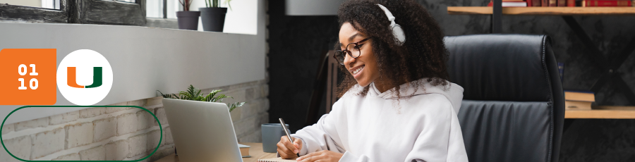 "Person with headphones working on a laptop at a desk in a well-lit room with plants and bookshelves."